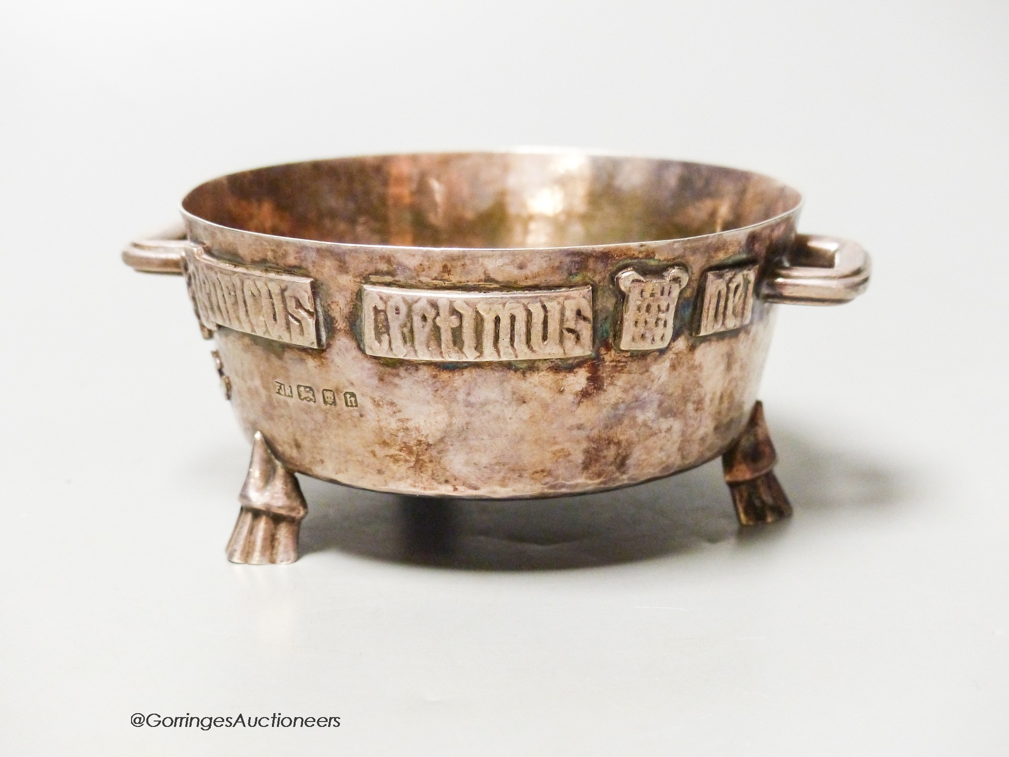 A George V Arts & Crafts planished silver twin-handled bowl, with applied Latin scripted border, F.J. Ross & Sons, London, 1923, diameter 10.5cm 7oz.